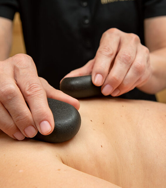 Hotstone Massage – angenehm warme Steine auf dem Rücken